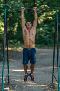 Full length of shirtless man standing outdoors