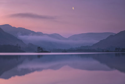 Scenic view of lake against mountains during sunset