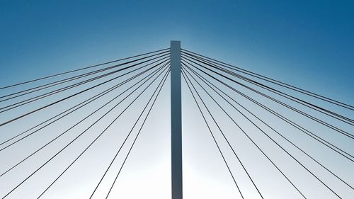 Low angle view of suspension bridge against clear blue sky