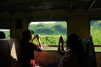 Tourists taking photographs from train