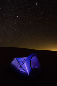 Tilt image of illuminated lighting equipment in sky at night