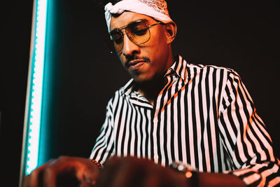 Concentrated african american male musician playing electric piano while rehearsing music in recording studio