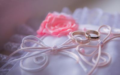 Close-up of wedding rings on white dress