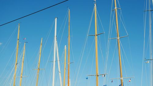 Low angle view of sailboat against clear blue sky