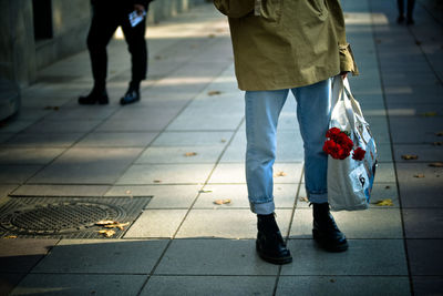 Low section of people walking on sidewalk