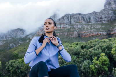 Portrait of young man standing against mountain