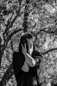 Midsection of man standing against trees in forest