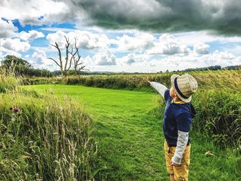 Scenic view of grassy field against sky