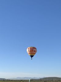 Low angle view of hot air balloon against clear blue sky