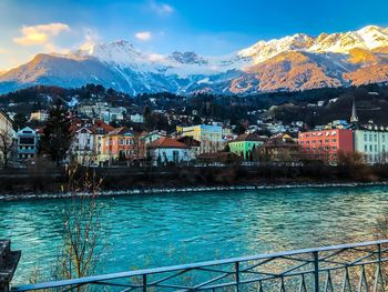 Scenic view of lake by buildings against sky during winter