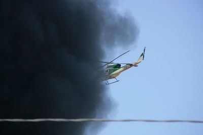 Low angle view of helicopter flying against sky