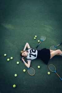 High angle view of tired young woman lying on court