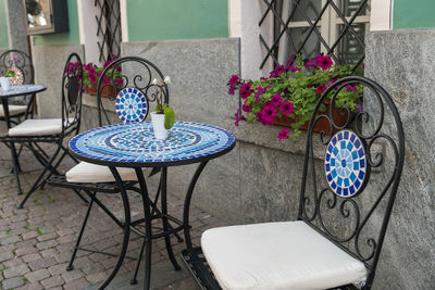 Empty chairs and tables against building