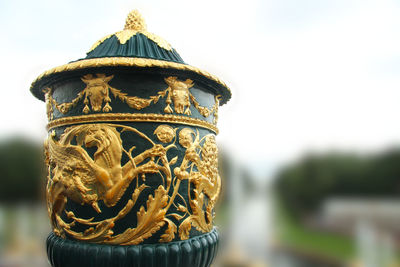 Close-up of ornate on built structure against sky