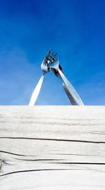 Low angle view of windmill against blue sky