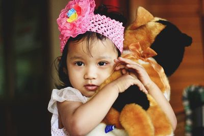 Close-up portrait of girl holding toy at home