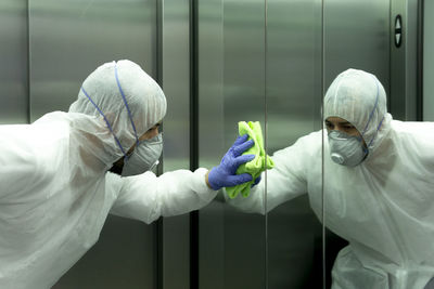 Coronavirus. worker disinfecting hospital elevator to avoid contagion.