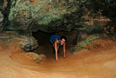 Portrait of smiling woman coming out from cave