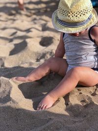 High angle view of girl sitting on sand