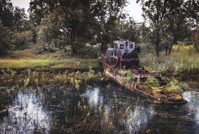 Abandoned boat by lake in forest