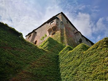 Low angle view of house on hill against sky