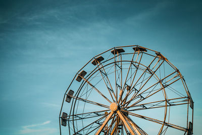 Low angle view of ferris wheel against blue sky