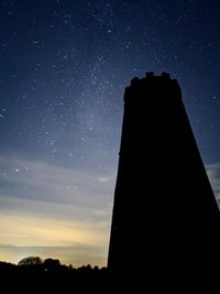 Low angle view of silhouette buildings against sky at night