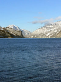 Scenic view of sea and mountains against blue sky