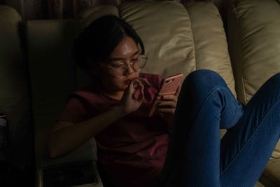 Mid adult woman sitting on sofa at home