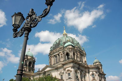 Low angle view of antique gas light by berlin cathedral against sky