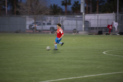 Teen soccer player dribbling the ball during a game