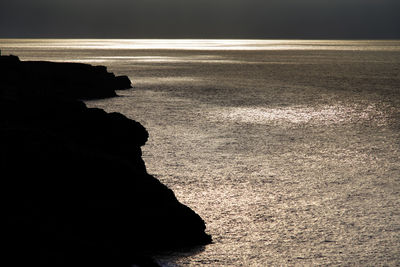 Rock formation on beach against sky