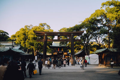 People walking on road against clear sky