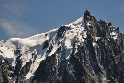 Low angle view of snowcapped mountains against sky