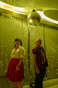 Man and woman standing by disco ball