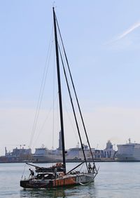 Sailboats moored on sea against sky