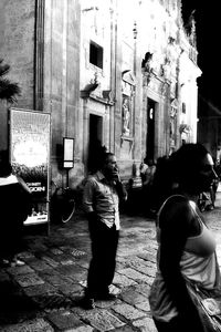 Young woman standing by railing