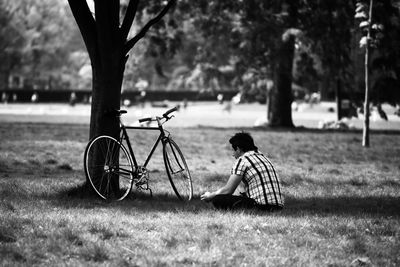 Man sitting on bicycle in field