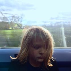 Close-up of girl looking through window