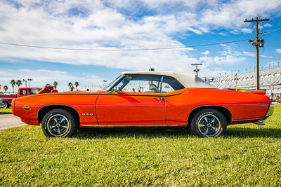 Vintage car on field against sky