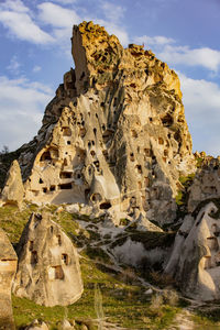 Rock formation on mountain against cloudy sky