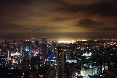 Aerial view of city against cloudy sky at night