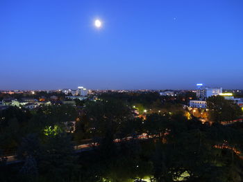 High angle view of illuminated buildings against clear sky at night