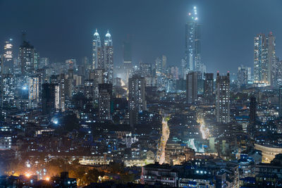 Illuminated cityscape against sky at night