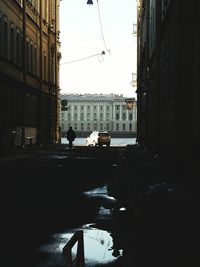 Cars on street in city against sky