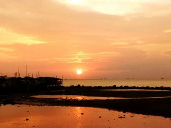 Scenic view of sea against dramatic sky during sunset