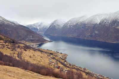 Scenic view of lake by mountains against sky