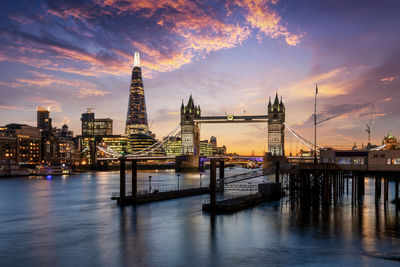 Tower bridge over thames river in city during sunset