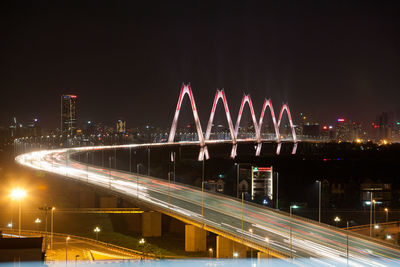 Light trails on road against sky at night