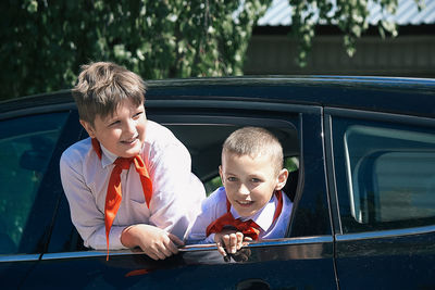 Happy boy with reflection of man in car